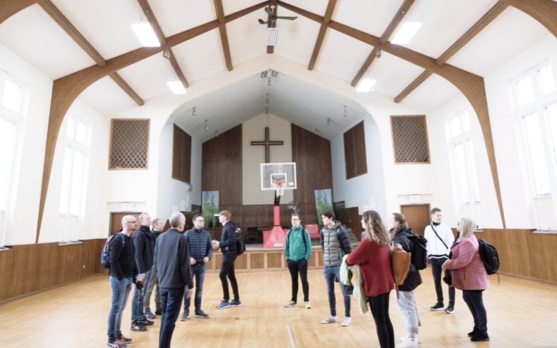 Basecamp deltakere i kirkesal med basketballbane