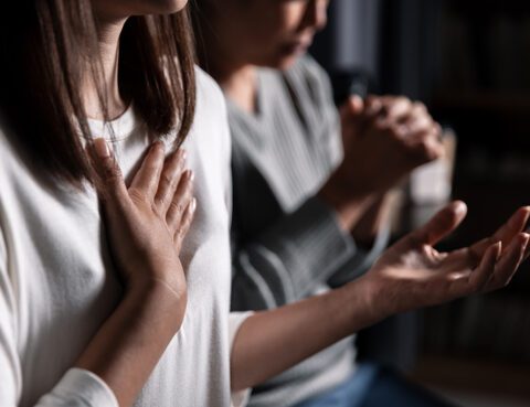 Foto av to personer som ber.